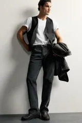 Chaleco regular fit de Zara confeccionado en tejido con lana, color negro, con cuello en V, manga sisa, bolsillos de vivo en la cintura, trabilla ajustable en la espalda y cierre frontal de botonadura.