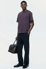 Pantalón negro de corte regular, confeccionado en una mezcla vaporosa de lino y algodón. Presenta cintura con elástico revestido y cordón de ajuste, cierre con botón y bragueta, bolsillos laterales y bolsillos traseros insertados.