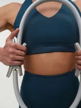 Top deportivo negro con espalda nadadora, copas removibles y detalle de logo sutil en el elástico inferior.