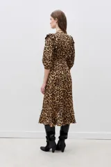 Vestido midi con estampado animal print de leopardo, escote en V cruzado, mangas 3/4 y detalles de volados en el escote, hombros y ruedo.
