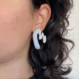 Par de aros colgantes dorados con forma abstracta.