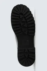 Bota tipo Chelsea fabricada en piel, con diseño de parte superior lisa, piezas elásticas laterales y tirador trasero. Presenta horma redonda y suela con volumen y piso track.