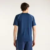 Remera deportiva New Balance Tournament de color azul marino, con cuello redondo, mangas raglán y detalles de ribete blanco en las costuras de los hombros. Cuenta con el logotipo de la marca impreso en el pecho.