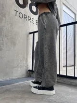 Pantalon de estilo deportivo con efecto lavado nevado, corte holgado y bolsillos laterales. Presenta costuras expuestas y cintura elástica.