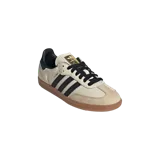 Championes Adidas Samba OG en color blanco crema, con las clásicas tres tiras laterales en negro, puntera de gamuza en tono tostado y suela de goma de estilo retro.