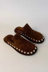 Sueco de gamuza color marrón con detalle de tachas metálicas doradas alrededor de la suela y punta redonda.