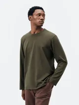 Remera marrón de manga larga, cuello redondo y diseño liso básico.