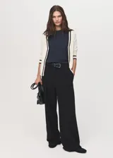 Cardigan de punto fino color blanco crudo, con diseño recto, escote en V, cierre frontal con botones y rayas negras en contraste en la tapeta y los puños.