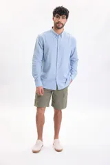 Bermuda cargo color verde militar, con bolsillos laterales con solapa y cierre de botones.