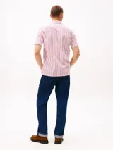 Camisa de manga corta confeccionada en tejido seersucker de algodón BCI a rayas rojas y blancas. Tiene cuello clásico, cierre con botones y logo de Tommy Hilfiger bordado en el pecho.