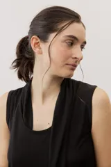 Vestido midi negro sin mangas, con cuello drapeado y diseño holgado.