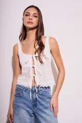 Blusa blanca de algodón con escote cuadrado, breteles anchos con detalle de puntilla y lazos ajustables en el frente.