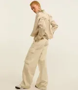 Pantalón wide leg de sarga color marrón chocolate, tiro alto, con bolsillos laterales tipo cargo y etiqueta con lettering en la cintura.