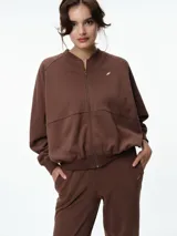 Campera deportiva color bordó con cuello tipo bomber, cierre frontal completo y mangas raglán. Presenta puños, cuello y ruedo acanalados, además de bolsillos frontales.