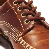 Zapatos Dr. Martens modelo Lowell de cuero marrón, con cordones, pespuntes amarillos en la suela y costuras destacadas en la puntera.