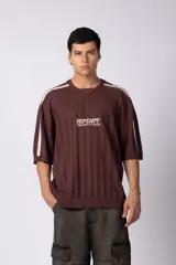 Remera de tejido de punto calado en color bordó, con cuello en V y mangas cortas. Presenta franjas laterales blancas en los hombros y un diseño gráfico bordado en el centro del pecho.