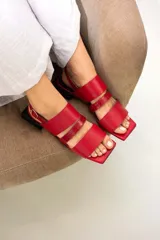 Sandalias rojas de cuero con tres tiras en la capellada, pulsera ajustable y taco cuadrado negro de 3 cm de altura.