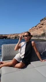 Vestido corto sin mangas con escote recto, confeccionado con paneles combinados: un lado negro liso y el otro blanco con estampado de lunares negros. Posee bolsillos ocultos laterales.