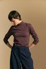 Polera de cuello alto y manga larga, confeccionada en tejido elástico con diseño de rayas horizontales en tonos azul marino y terracota.
