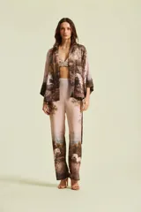 Kimono de mujer con silueta amplia y envolvente, mangas murciélago y lazo para ajustar en la cintura. Presenta un estampado de paisaje editorial con caballos.