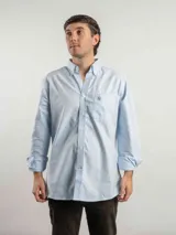 Camisa Oxford de corte clásico, confeccionada 100% en algodón con patrón de cuadros en tonos blancos, azules y amarillos. Cuenta con cuello abotonado, bolsillo frontal en el pecho con logo bordado y cierre de botones.