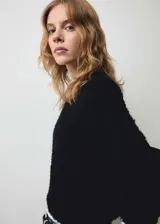 Jersey de punto grueso con efecto pelo, cuello redondo y manga larga. Diseño recto y textura suave.