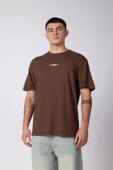Remera marrón de corte regular, con cuello redondo, mangas cortas y pequeño estampado en el centro del pecho.