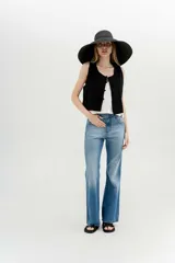 Chaleco negro de algodón con escote recto y corte recto. Presenta tres botones forrados al frente.