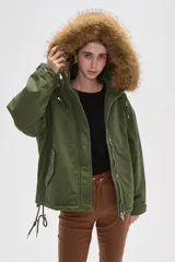 Campera negra de algodón con capucha, cierre frontal oculto y bolsillos laterales. Presenta un diseño holgado con detalles de piel sintética en el borde de la capucha.