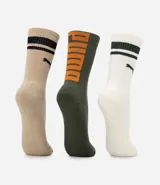 Kit de tres pares de medias deportivas Puma de caña larga. Un par es beige con dos rayas marrones y logo de Puma. Otro par es blanco liso. El tercer par es marrón oscuro con dos rayas blancas y logo de Puma. Todas están confeccionadas en algodón.