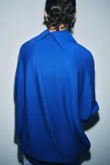 Jersey de lana en color azul vibrante, con cuello subido y diseño de manga murciélago con sisa ancha. Presenta puños ajustados y un corte holgado que se extiende hasta la cadera.