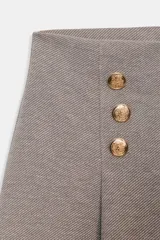 Pantalón de tiro alto con pierna ancha, confeccionado en sarga color tostado. Presenta detalle de doble hilera de botones metálicos dorados en el frente y pinzas verticales.