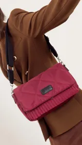 Bandolera capitoneada color bordó, con bolsillo interno, correa de galón ajustable y tapa con broche.