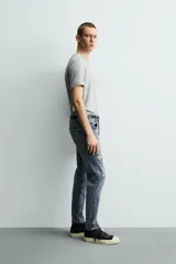 Jeans skinny fit de corte ajustado y tiro medio en color negro con efecto lavado y detalles desgastados. Confeccionados en tejido elástico con mezcla de algodón, presentan diseño clásico de cinco bolsillos y cierre frontal con cremallera y botón.