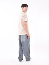 Remera color beige con estampado circular con texto en marrón.