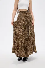 Falda larga de poliéster con estampado animal print de leopardo, diseño de corte amplio con volados en el ruedo y cierre frontal con botones.