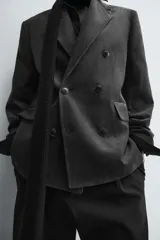 Blazer de corte regular confeccionada en pana de algodón, con diseño de botonadura cruzada. Presenta cuello con solapas de pico, manga larga con puños abotonados, bolsillos con solapa en la cadera y abertura central en la espalda.