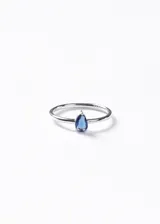 Anillo fino de plata 925 con una zirconia central en forma de gota de color azul.