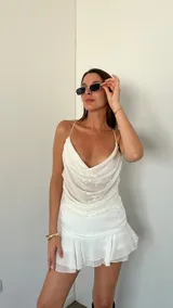 Top blanco con lentejuelas, breteles finos y escote drapeado.