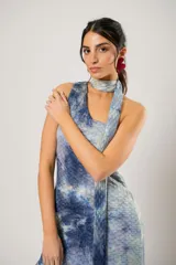 Vestido corto con estampado abstracto en tonos azules y beige. Presenta escote halter con pañuelo al cuello, corte irregular y ruedo con volados.