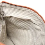 Bandolera de cuero color suela, con diseño plegable, cierre frontal y cadena metálica decorativa en uno de los laterales. Incluye logo de la marca grabado en el centro.