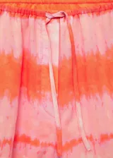 Short de algodón con diseño estampado en tonos rosados y naranjas, corte recto, cintura elástica con lazo ajustable y bolsillos laterales.