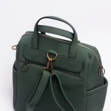 Mochila de diseño versátil en color verde, confeccionada con una combinación de texturas. Presenta un cuerpo principal de cuero sintético texturizado y un bolsillo frontal amplio de gamuza. Incluye manijas superiores para llevar en la mano, bolsillos laterales abiertos y cierre principal con cremallera.