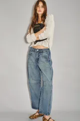 Jean de tiro medio-alto, de calce holgado con piernas anchas que se estrechan hacia el tobillo. Presenta pinzas en la zona de las rodillas que acentúan su forma balloon. Confeccionado en denim rígido azul, con cierre y botón.