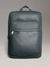 Mochila Calvin Klein color verde oscuro, de cuero sintético con textura micro pebble. Tiene un bolsillo frontal con cierre, asa de mano y correas acolchadas ajustables. Interior con funda acolchada para laptop, bolsillo con cierre y portabolígrafos.