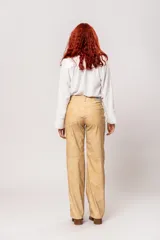 Pantalón de tiro alto color beige con estampado difuminado, bolsillos laterales y cierre frontal con cremallera y botón.