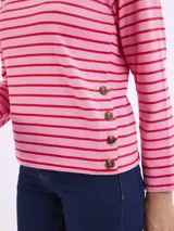 Blusa de manga larga con diseño a rayas horizontales en tonos rosa y rojo. Presenta cuello redondo y detalle de botones decorativos en el lateral inferior.