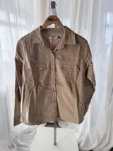 Chemise de pana elastizada color camel de la marca Bartola, con cuello camisero, cierre frontal de botones, bolsillos con solapa en el pecho y estilo western.