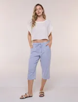 Pantalón capri de algodón a rayas verticales en tonos azul, celeste y blanco, con cintura elastizada, cordón de ajuste frontal y bolsillos aplicados.