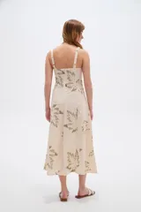 Vestido midi de viscosa color beige con estampado de hojas en tonos verdosos, de corte holgado, con tirantes finos regulables y escote cuadrado.